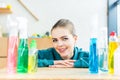 young woman smiling at camera while sitting at table with plastic bottles Royalty Free Stock Photo