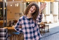 Young woman smiling friendly at camera, waving hands hello, hi, greeting or goodbye in city street Royalty Free Stock Photo