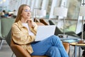 Girl student using laptop computer sitting in university looking away thinking. Royalty Free Stock Photo