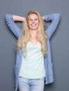 Young woman smiling with hands behind head