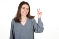 Young woman smiling happy sucess showing two fingers v positive and peace gesture white background Royalty Free Stock Photo