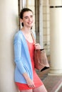 Young woman smiling and leaning against wall with bag Royalty Free Stock Photo