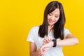 Young woman smiling looking and pointing finger her smart wristwatch Royalty Free Stock Photo