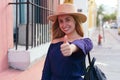 Young woman smiling and making thumb up outdoors Royalty Free Stock Photo