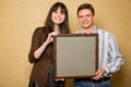 Young woman and smiling man with picture in frame Royalty Free Stock Photo
