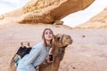 Young woman smiling posing with a camel in the middle of the jordan desert Royalty Free Stock Photo