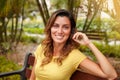 Young woman smiling while sitting on park bench