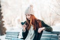 Young woman smiling with smart phone and winter Royalty Free Stock Photo