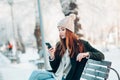 Young woman smiling with smart phone and winter Royalty Free Stock Photo