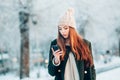 Young woman smiling with smart phone and winter Royalty Free Stock Photo