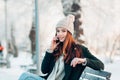 Young woman smiling with smart phone and winter Royalty Free Stock Photo