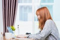 Young woman smiling, student girl sitting on chair during working with laptop computer at home office Royalty Free Stock Photo