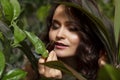 Young woman sniffs aromas of natural oils. Beautiful brunette in greenery plants. Close-up Royalty Free Stock Photo