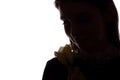 Young woman sniffs a flower - horizontal side view silhouette Royalty Free Stock Photo