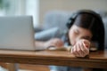 Young woman snoozing at laptop during boring webinar or lecture, concept of online work or study