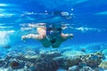 Young woman snorkels in tropical water of Thailand