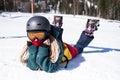 Young happy woman snowboarder lying on a snowy slope. Royalty Free Stock Photo