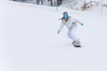 Young woman snowboarder in motion on snowboard in mountains Royalty Free Stock Photo