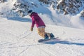 Young woman snowboarder in motion on snowboard in mountains Royalty Free Stock Photo