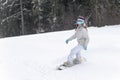 Young woman snowboarder in motion on snowboard in mountains Royalty Free Stock Photo