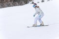 Young woman snowboarder in motion on snowboard in mountains Royalty Free Stock Photo