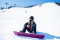 Young woman snowboarder sitting on a snowy slope. Sport. Royalty Free Stock Photo