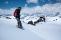 Young woman snowboarder stands on a snowboard on the slope getting ready to roll freeride backcountry down on a sunny Royalty Free Stock Photo