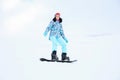 Young woman snowboarding on hill at mountain resort. Winter Royalty Free Stock Photo