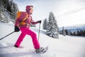 Young woman snowshoeing in high mountains