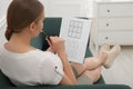 Young woman solving sudoku puzzle on sofa Royalty Free Stock Photo