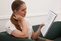 Young woman solving sudoku puzzle on sofa indoors Royalty Free Stock Photo