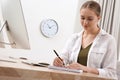 Young woman solving sudoku puzzle at workplace in office Royalty Free Stock Photo