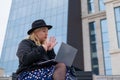 Young woman speaks sign language on a video call on a laptop outdoors. The deaf-mute girl communicates with gestures