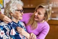 Young woman spending time with her elderly grandmother at home