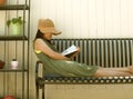 Young Woman Spending Time at Home Self Isolation Reading a Book in Back yard Gardening