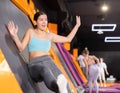 Young woman in sport clothes jumping on vertical trampoline