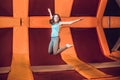 Young woman sportsman jumping on a trampoline in fitness park and doing exersice indoors Royalty Free Stock Photo