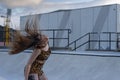 Young woman in sportswear dancing energetically in a skate park Royalty Free Stock Photo