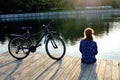 Young athletic woman in sportswear sits next to a bicycle Royalty Free Stock Photo