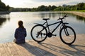 Young athletic woman in sportswear sits next to a bicycle Royalty Free Stock Photo