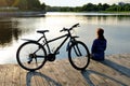 Young athletic woman in sportswear sits next to a bicycle Royalty Free Stock Photo