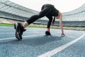 Young woman in sportswear in starting position on running track stadium Royalty Free Stock Photo