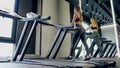 Young woman with sporty body doing cardion on treadmill.