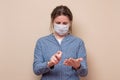 Young woman spraying her hands with sanitizer protecting herself from virus