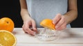 Young woman squeezes orange juice using a manual glass juicer Royalty Free Stock Photo