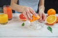 Young woman squeezes orange juice using a glass juicer Royalty Free Stock Photo