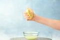 Young woman squeezing lemon juice into bowl Royalty Free Stock Photo