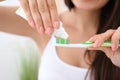 Young woman squeezing toothpaste on brush in bathroom, closeup Royalty Free Stock Photo