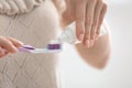 Young woman squeezing toothpaste on brush, closeup Royalty Free Stock Photo