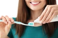 Young woman squeezing toothpaste on brush, closeup Royalty Free Stock Photo